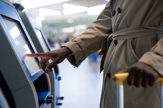 Black Traveler Man Using Self Check-in Machine Kiosk Service At Airport, Finger Point On Display. Close Up. 