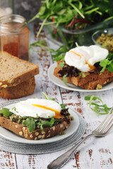 Homemade sandwiches with pesto, green salad and poached eggs
