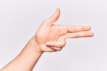 Close up of hand of young caucasian man over isolated background gesturing fire gun weapon with fingers, aiming shoot symbol