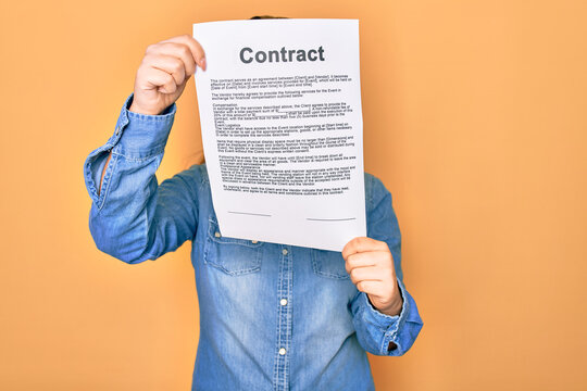 Woman holding contract document paper standing over isolated yellow background