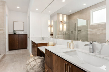 Beautiful bathroom in new luxury home with double vanity and two large sinks. Mirror reflection...