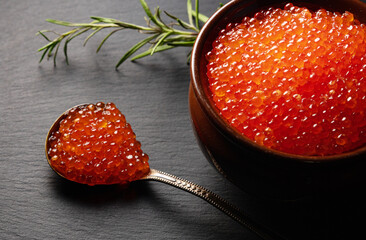 Red caviar in pot on stone plate.