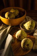 cherimoya fruit in sunlight, dark background