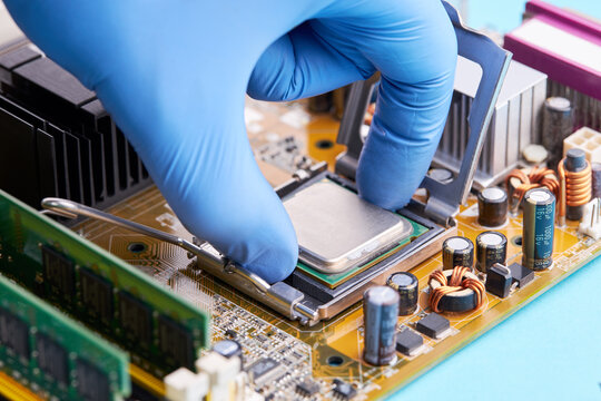computer hardware service concept. technician repairing desktop pc or laptop circuit board. person install cpu chip to pcb socket
