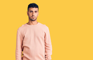 Young hispanic man wearing casual clothes relaxed with serious expression on face. simple and natural looking at the camera.