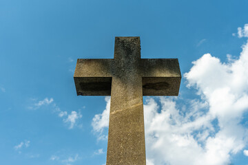 Large cross symbol made of stone against a blue sky
