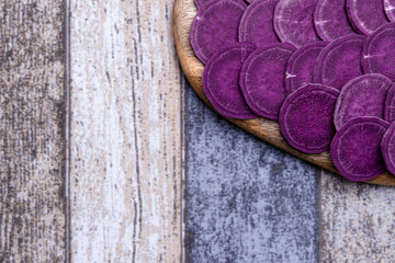 Foreground of the chopped sweet potato on the cutting board, background out of focus, healthy and ecological food.