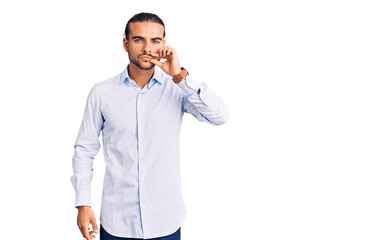 Young handsome man wearing business clothes mouth and lips shut as zip with fingers. secret and...