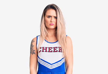 Young beautiful blonde woman wearing cheerleader uniform depressed and worry for distress, crying angry and afraid. sad expression.