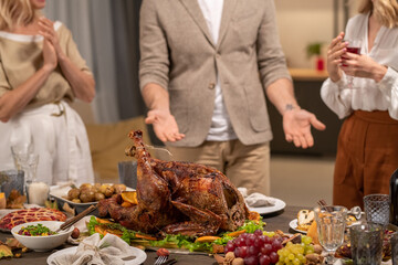 Homemade roasted turkey among fresh fruits, salad and desserts on served table