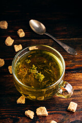 Cup of green tea with brown tea sugar