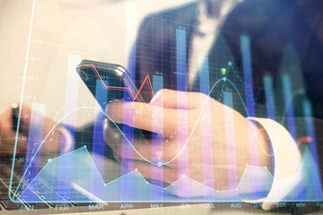 Multi exposure of man's hands holding and using a digital phone and forex graph drawing. Financial market concept.