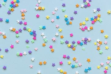 Trendy plastic colorful stars confetti on blue background. Birthday party festive polymer clay...