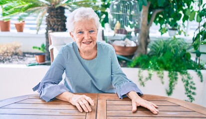 Elder senior woman with grey hair smiling happy at home