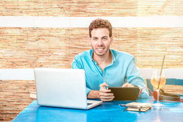 young freelance guy working on laptop outside connected to the internet