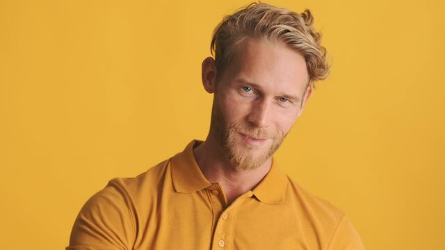 Handsome cool blond bearded man confidently showing see you later gesture on camera over colorful background