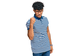 Young arab man wearing casual clothes and glasses angry and mad raising fist frustrated and furious...