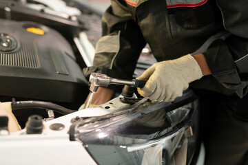 Fototapeta na wymiar Gloved hand of worker of contemporary car maintenance center using handtool