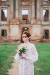 Fototapeta premium Pretty young caucasian redhead girl in garden and outside with wedding bouquet.