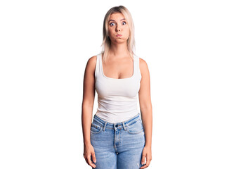 Fototapeta premium Young beautiful blonde woman wearing casual sleeveless t-shirt puffing cheeks with funny face. mouth inflated with air, crazy expression.