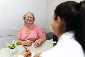 Joyful senior patient with big smile talking to doctor in doctors office health, medical, medicine...