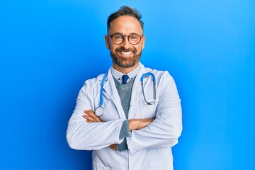 Handsome middle age man wearing doctor uniform and stethoscope happy face smiling with crossed arms...