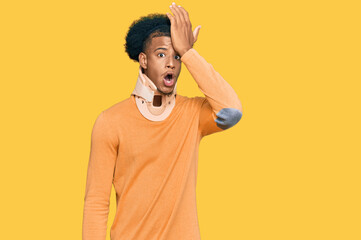 African american man with afro hair wearing cervical neck collar surprised with hand on head for mistake, remember error. forgot, bad memory concept.