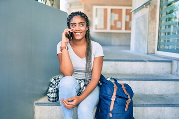 Young african american student woman smiling happy using smartphone at the university campus