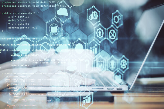 Hand using laptop with business analytics diagram and programming backdrop.