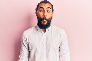 Fototapeta premium Young arab man wearing casual clothes making fish face with lips, crazy and comical gesture. funny expression.