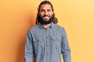 Young arab man wearing casual clothes looking positive and happy standing and smiling with a confident smile showing teeth