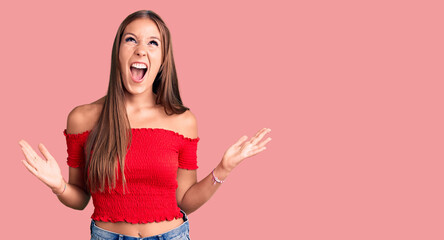 Young beautiful hispanic woman wearing casual clothes crazy and mad shouting and yelling with aggressive expression and arms raised. frustration concept.