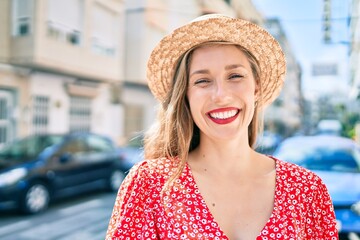 Young blonde woman on vacation smiling happy walking at street of city