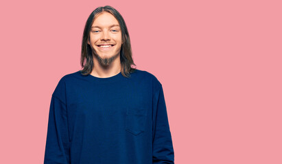 Fototapeta premium Handsome caucasian man with long hair wearing casual winter sweater with a happy and cool smile on face. lucky person.