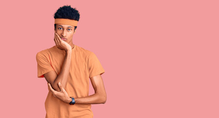 Young african american man wearing sportswear thinking looking tired and bored with depression problems with crossed arms.