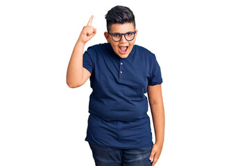 Fototapeta premium Little boy kid wearing casual clothes and glasses pointing finger up with successful idea. exited and happy. number one.
