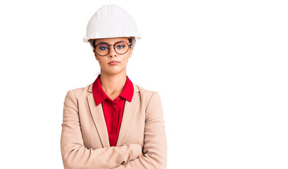 Young beautiful woman wearing architect hardhat skeptic and nervous, disapproving expression on face with crossed arms. negative person.