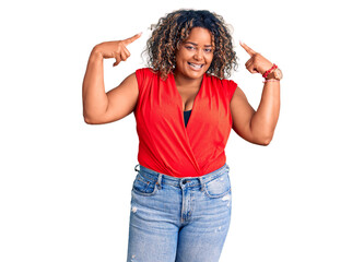 Young african american plus size woman wearing casual style with sleeveless shirt smiling pointing to head with both hands finger, great idea or thought, good memory