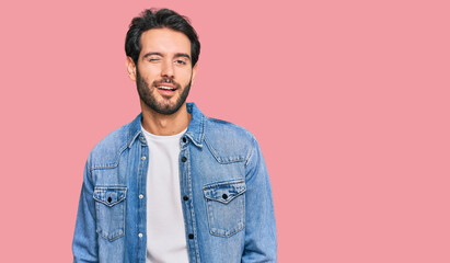 Young hispanic man wearing casual clothes winking looking at the camera with sexy expression, cheerful and happy face.