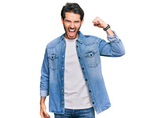 Young hispanic man wearing casual clothes angry and mad raising fist frustrated and furious while shouting with anger. rage and aggressive concept.