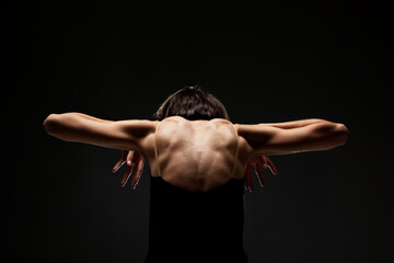 Fototapeta na wymiar half silhouette modern ballet dancer posing on dark background with smoke