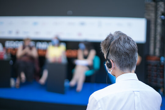 Man With Face Mask And Earphones Watching A Presentation Event