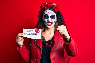 Woman wearing day of the dead costume holding happy halloween paper annoyed and frustrated shouting with anger, yelling crazy with anger and hand raised