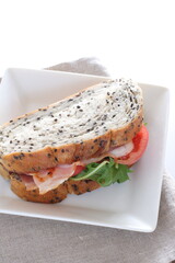 Homemade sesame bread and bacon sandwich on dish for comfort breakfast