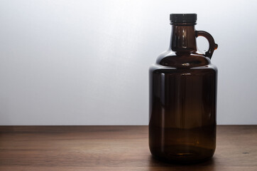 Growler bottle for craft beer on wooden table.