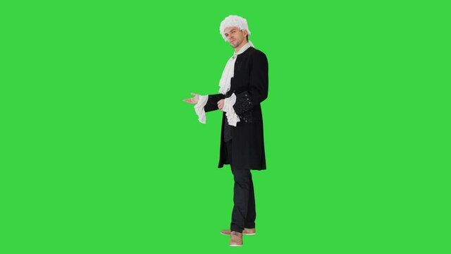Man in 18th century camisole and wig doing welcoming gesture on a Green Screen, Chroma Key.