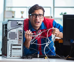 Computer repairman working on repairing computer in IT workshop