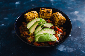 plant-based food,  vegan nourish bowls with tomato and bean mix with avocado and corn