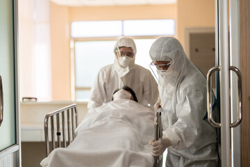 Hospital staff in PPE suit take Covid 19 patient for SWAB test