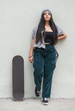portrait of young latin woman with skateboard